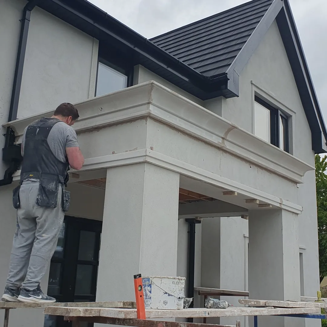 A Munster Coving fitter finishing the moulded cornice on an exterior portico
