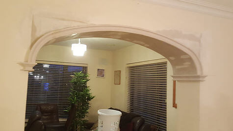 Plaster archway with moulded imposts between two rooms