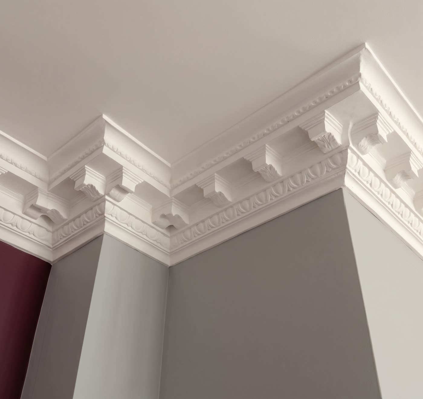 Layered plaster cornice with dentil detail at a ceiling corner